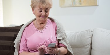 Woman holding mobile phone checking the NHS test and trace app