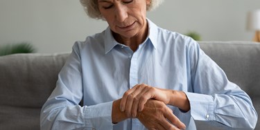 Woman holding her wrist seemingly in pain
