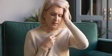 Woman holding head looking unwell