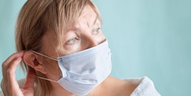 Woman wearing facemask suffering with anxiety