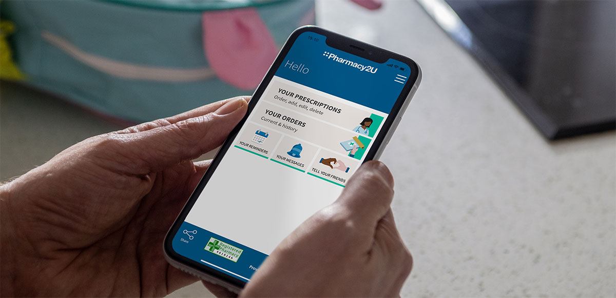 Person holding phone with pharmacy2u app on screen
