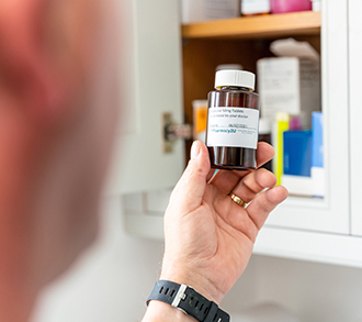 Person holding prescription taken from cabinet